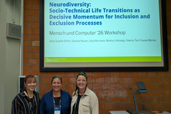 Drei lächelnde Frauen stehen vor einer projizierten Folie, auf der das Wort „Neurodiversity“ zu lesen ist.