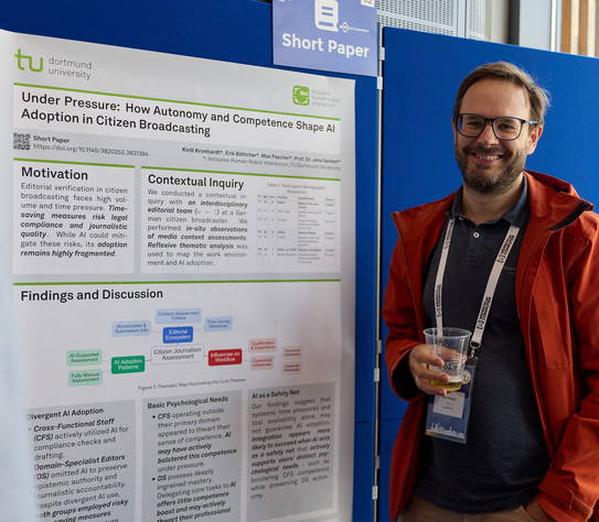 Jens Gerken (Mann mit braunen Bart und Brille) steht vor sein Short Paper Contribution Poster
