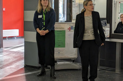 Zwei Personen stehen in einem Eingangsbereich eines Gebäudes der Technischen Universität Dortmund. Hinter ihnen befindet sich eine Informationssäule mit Plakaten.