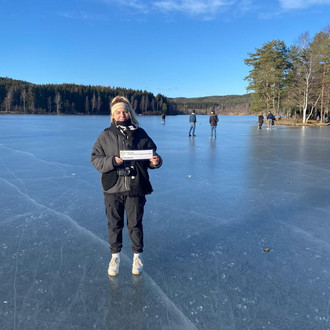 Studentin mit Fakultätslogo auf einem gefrorenen See in Oslo