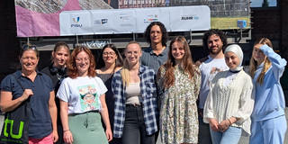 10 Personen vor einem Plakat der FISU World University Games