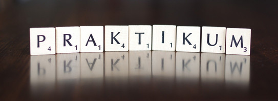 Spielsteine mit Buchstaben, die das Wort "Praktikum" bilden