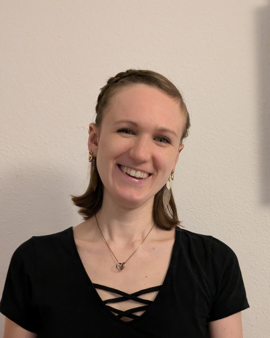 Portraitaufnahme von Niatti Schlemermeyer, man sieht eine lachende blonde Frau mit schulterlangen Haaren und einem schwarzen T-Shirt