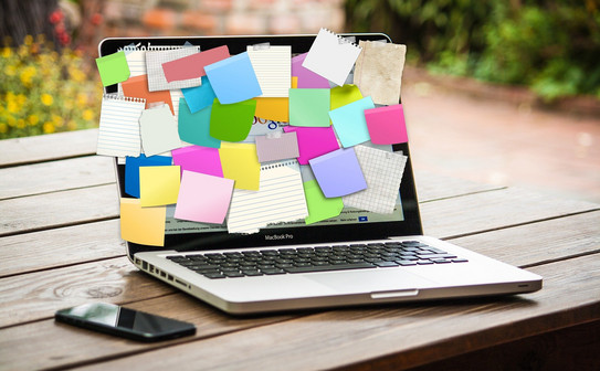 Laptop, dessen gesamter Bildschirm mit bunten Post-its beklebt ist