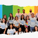 Zu sehen sind Studierende und Professor*innen des NeuroRehab (Forschungs- und Versorgungszentrum für neuropsychomotorische Rehabilitation) vor einem Regenbogenhintergrund, aufgenommen im Rahmen des internationalen Kongresses zum zehnjährigen Bestehen des Zentrums in Brasilien.
