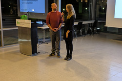 Eine Person spricht in ein Mikrofon, während die andere zuhört.