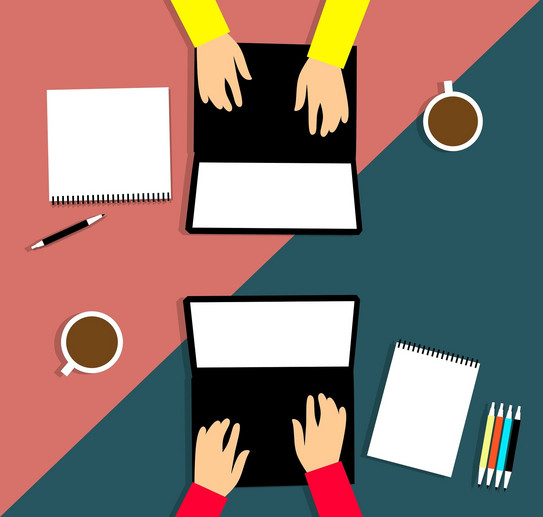 Zwei Computer von oben, zwei Paar Hände, die daran arbeiten, zwei Tassen Kaffe auf der Seite und Zettel und Stifte