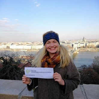 Studentin mit Fakultätslogo auf einem Ausguck in Budapest