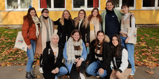 Eleven students in front of a building