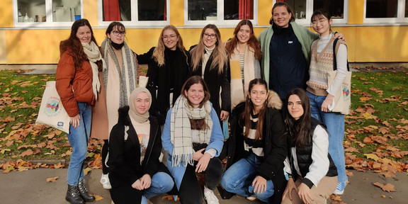 Eleven students in front of a building