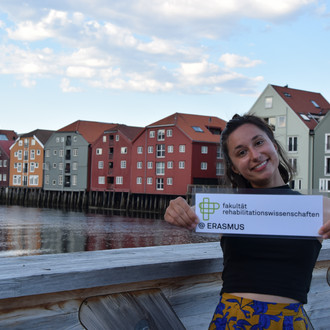 Studentin mit Fakultätslogo auf der Skansenbrücke in Trondheim