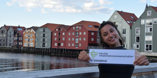 Studentin mit Fakultätslogo auf der Skansenbrücke in Trondheim