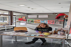 Ein Stand der Aidshilfe Dortmund e.V., gestaltet mit bunten Plakaten zum Thema Sexualität und Gesundheit. Eine Person sitzt am Tisch, auf dem Broschüren, Buttons und Informationsmaterial ausliegen.