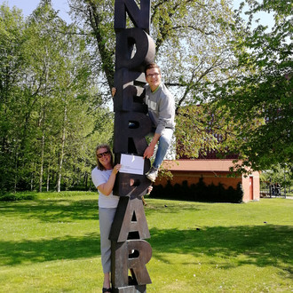 Zwei StudentInnen mit Fakultätslogo auf einem Baum mit LINKÖPING Buchstaben