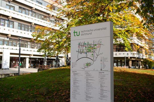 Campusplan Eine Infosäule mit Campusplan vor einem Gebäude.